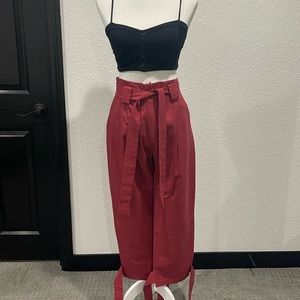 Ankle length coral pants with ruched waist and ribbon belt tie.